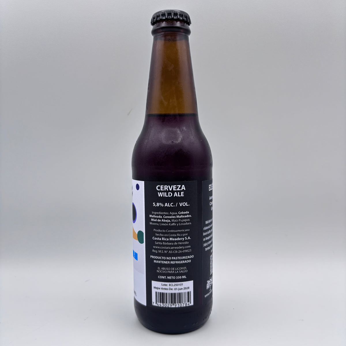 Vista trasera de la botella de Cerveza Wild Ale mostrando el porcentaje de alcohol (5.8% Alc/Vol), información de Costa Rica Meadery y código de barras sobre un fondo neutro.