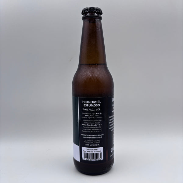Vista trasera de la botella de Hidromiel Espumoso mostrando la contraetiqueta con el porcentaje de alcohol (7.0% Alc/Vol), detalles de Costa Rica Meadery y código de barras sobre un fondo neutro.