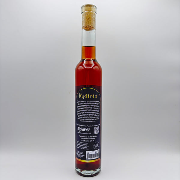 Vista trasera de la botella de hidromiel Melinia mostrando la contraetiqueta con la descripción del producto, el logo de Costa Rica Meadery y el código de barras sobre un fondo neutro.