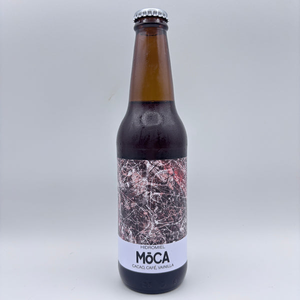 Botella de hidromiel Möca elaborado con cacao, café y vainilla, con una etiqueta con ilustración abstracta en tonos oscuros sobre un fondo neutro.