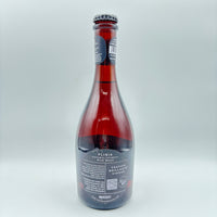 Vista lateral de la botella de Plinia Hidromiel Espumoso Wild Mead mostrando en la etiqueta los descriptores Festivo, Brillante y Vinoso, junto con un código QR y el logo de Costa Rica Meadery sobre un fondo neutro.